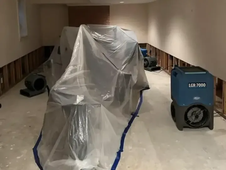 Containment plastic and an LGR dehumidifier drying a room with the lower walls opened